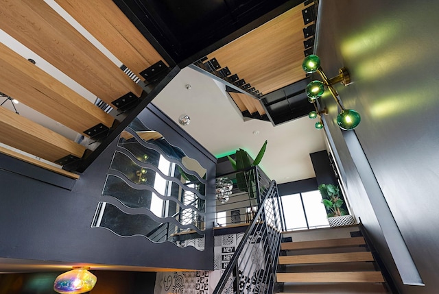 staircase with beamed ceiling and a towering ceiling