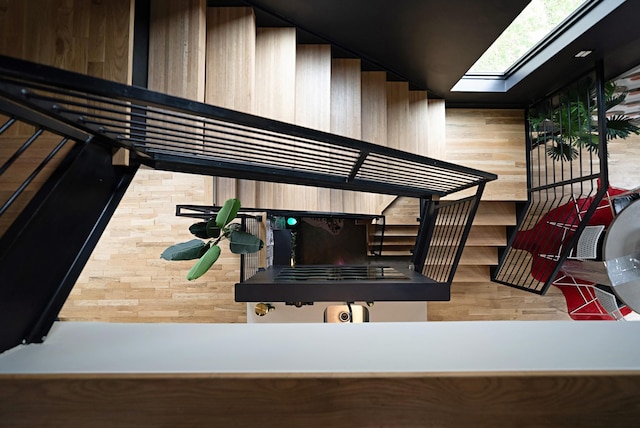 stairs featuring a skylight and wooden walls