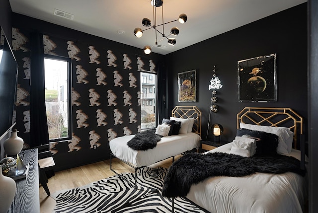 bedroom with a chandelier and wood-type flooring