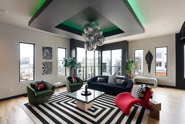 living room with a tray ceiling and light hardwood / wood-style flooring