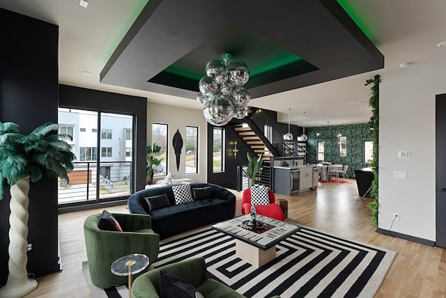 living room with a tray ceiling and light hardwood / wood-style flooring