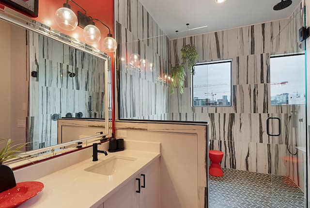 bathroom with tile walls, vanity, and an enclosed shower