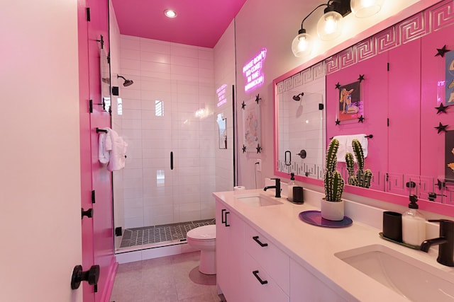 bathroom featuring tile patterned flooring, vanity, toilet, and a shower with door