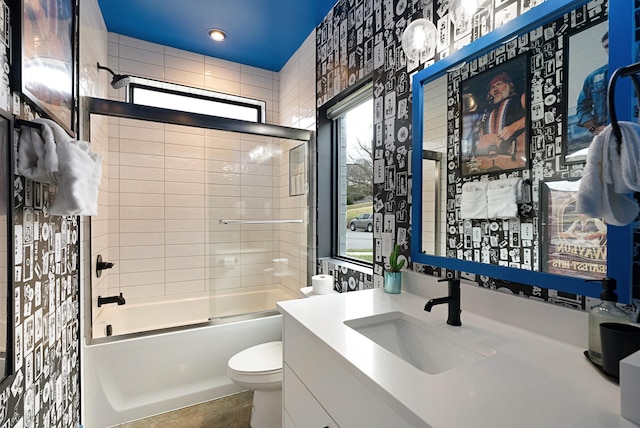 full bathroom featuring vanity, a healthy amount of sunlight, and tiled shower / bath