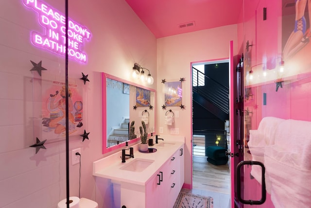 bathroom with hardwood / wood-style flooring, vanity, and an enclosed shower