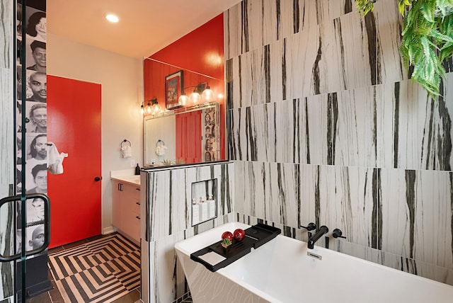 bathroom with tile patterned flooring, vanity, and a washtub