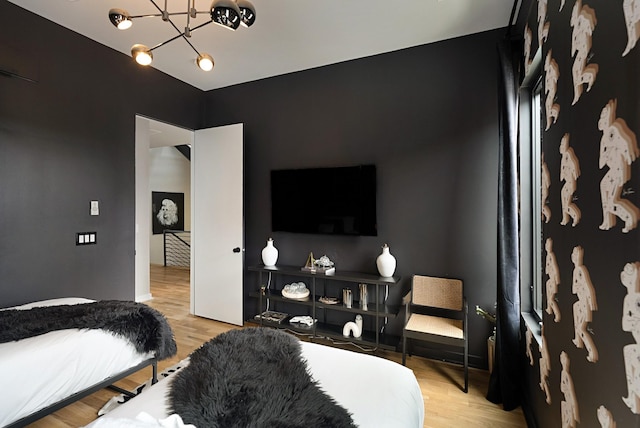 bedroom featuring a notable chandelier and light wood-type flooring