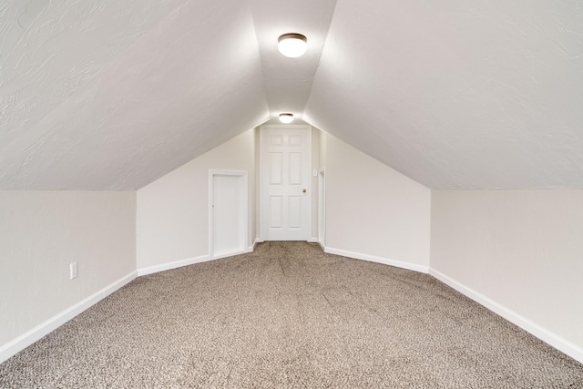 bonus room with carpet flooring, a textured ceiling, and vaulted ceiling