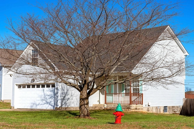 view of front of home with a porch, a garage, and a front lawn