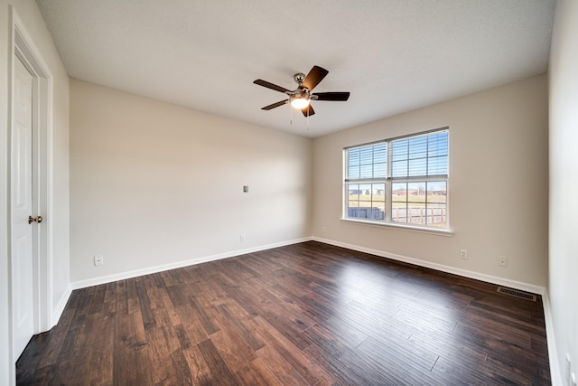 spare room with ceiling fan and dark hardwood / wood-style floors