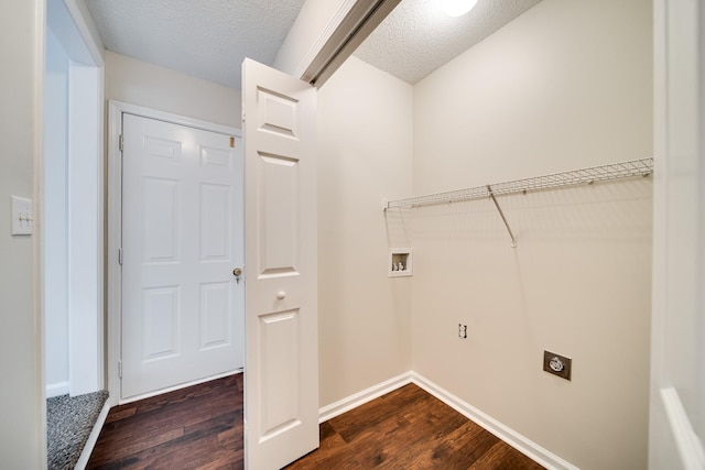 laundry area featuring dark wood-type flooring, a textured ceiling, and hookup for an electric dryer