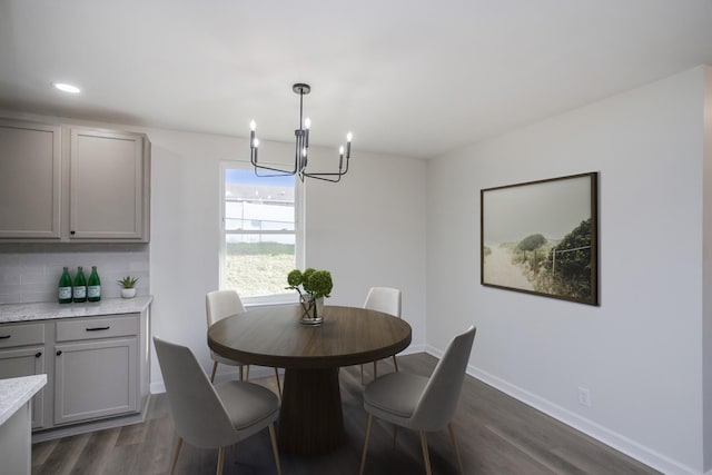 dining area with dark hardwood / wood-style flooring and a notable chandelier