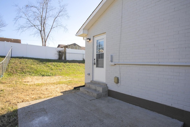 entrance to property with a patio area and a yard