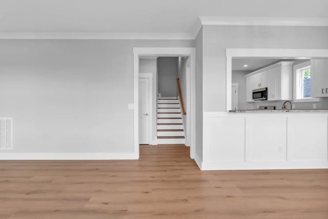4217 Oakland Ave Lot 194, Chattanooga, TN 37410 - unfurnished living room featuring visible vents, ornamental molding, stairs, a sink, and light wood finished floors