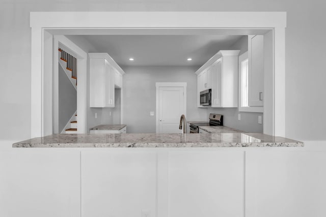 4217 Oakland Ave Lot 194, Chattanooga, TN 37410 - kitchen with light stone counters, white cabinets, a peninsula, stainless steel electric stove, and recessed lighting