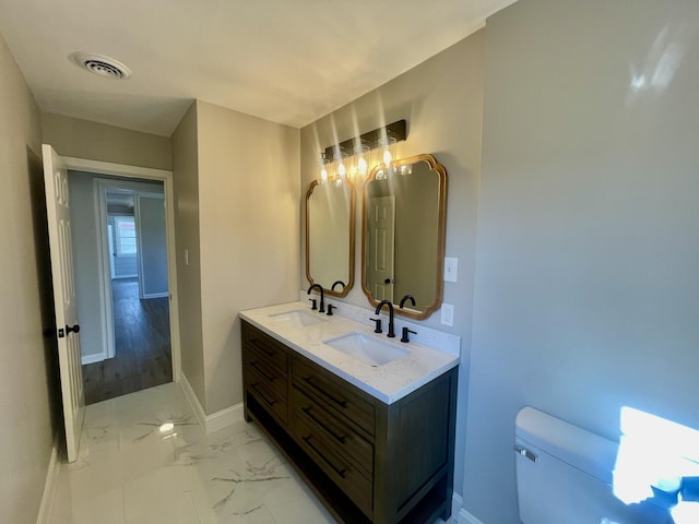 bathroom with wood-type flooring, vanity, and toilet