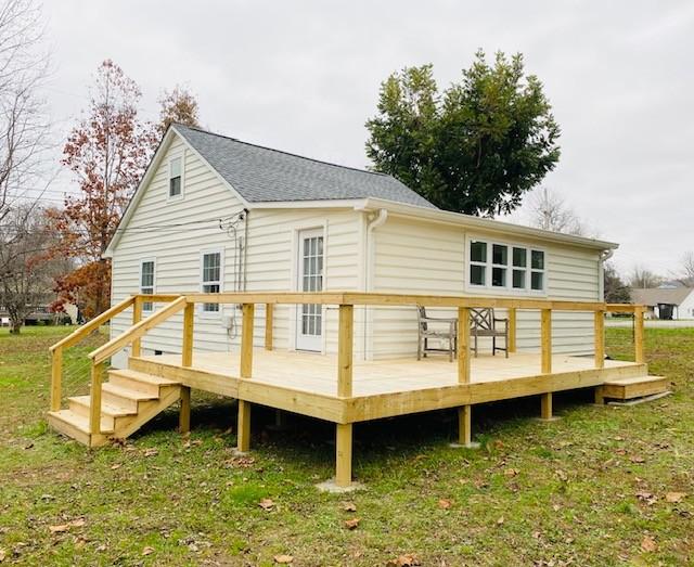 rear view of house with a yard and a deck