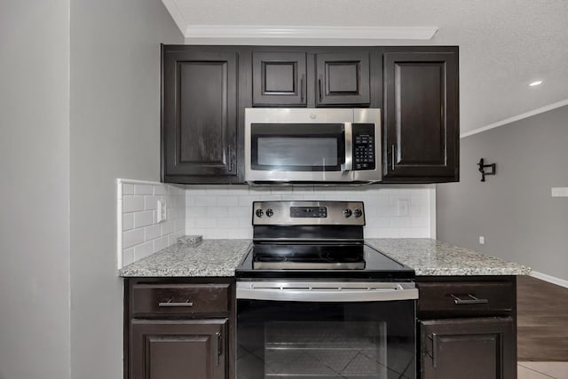 kitchen with crown molding, light hardwood / wood-style flooring, decorative backsplash, appliances with stainless steel finishes, and dark brown cabinetry