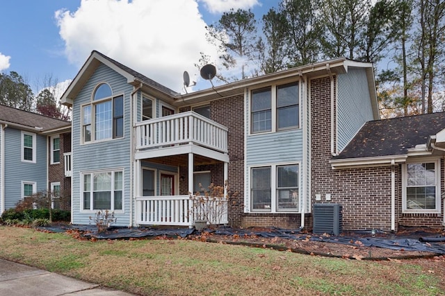 rear view of property with a lawn and a balcony