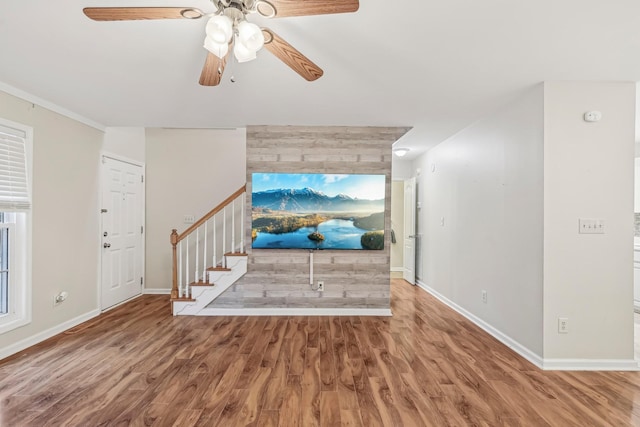 unfurnished living room with hardwood / wood-style floors, ceiling fan, and ornamental molding