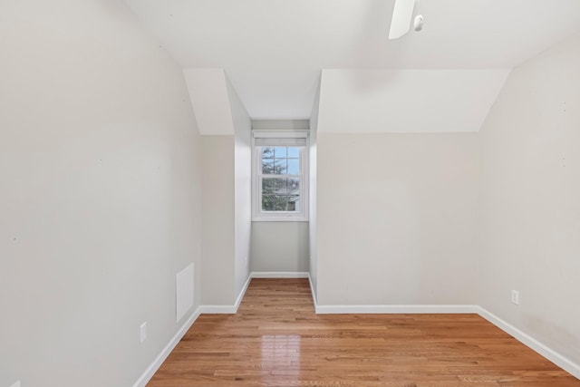 empty room with light hardwood / wood-style floors and lofted ceiling