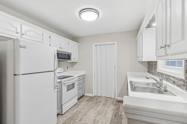 kitchen with white cabinetry, sink, light hardwood / wood-style floors, and white appliances