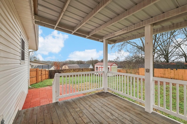 wooden deck featuring a patio and a storage shed