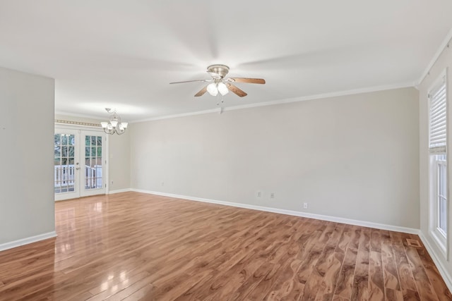 spare room with hardwood / wood-style floors, ceiling fan with notable chandelier, crown molding, and french doors