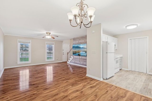 interior space featuring ceiling fan with notable chandelier, crown molding, and light hardwood / wood-style flooring