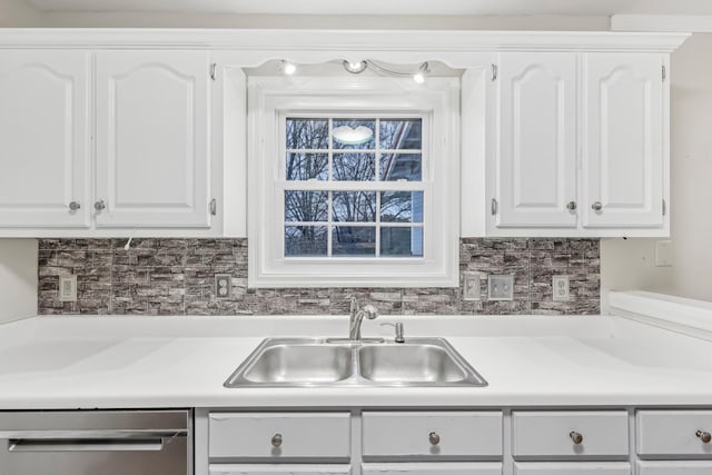 kitchen featuring backsplash, white cabinetry, sink, and dishwasher