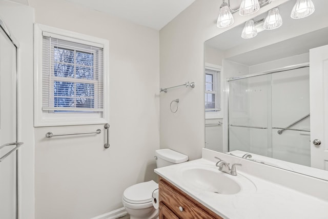 bathroom featuring vanity, toilet, and a shower with door