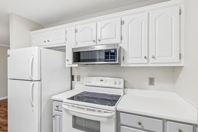 kitchen with hardwood / wood-style floors, white appliances, and white cabinetry