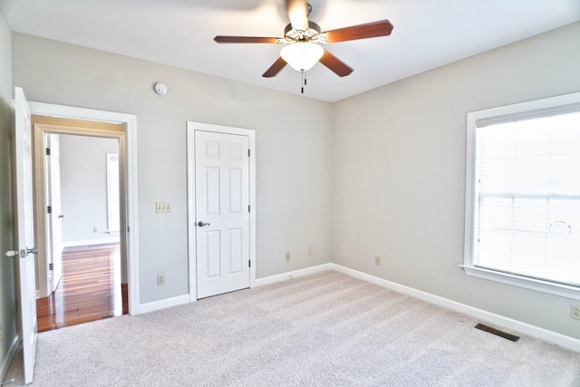 unfurnished bedroom with light carpet and ceiling fan