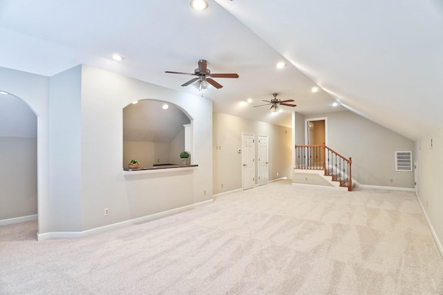 unfurnished living room with ceiling fan, light colored carpet, and lofted ceiling