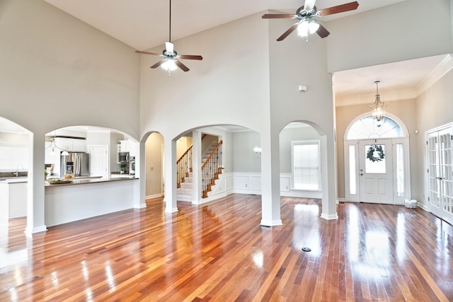 entrance foyer featuring sink, high vaulted ceiling, and wood-type flooring