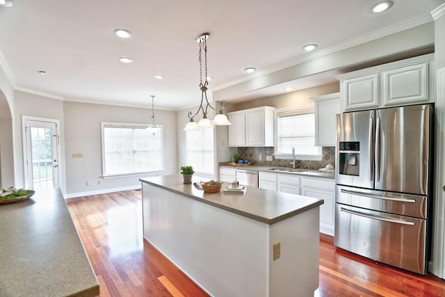 kitchen with dark wood-type flooring, a kitchen island, stainless steel appliances, and sink