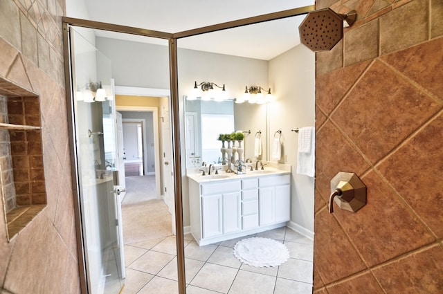 bathroom featuring tile patterned flooring, vanity, and tiled shower