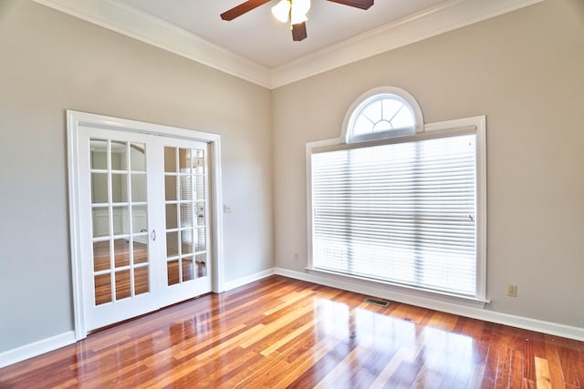 unfurnished room featuring hardwood / wood-style flooring, ceiling fan, ornamental molding, and french doors