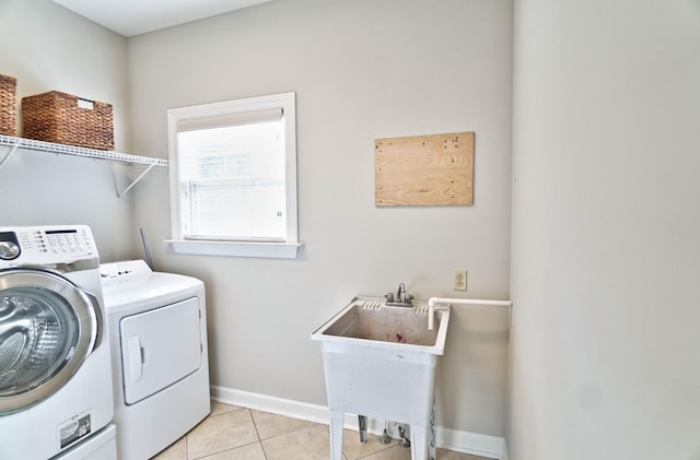 laundry area with light tile patterned flooring, sink, and washing machine and clothes dryer