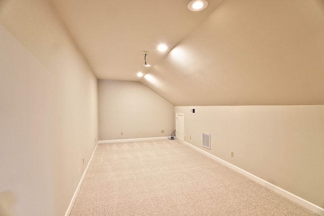 bonus room featuring light colored carpet and vaulted ceiling