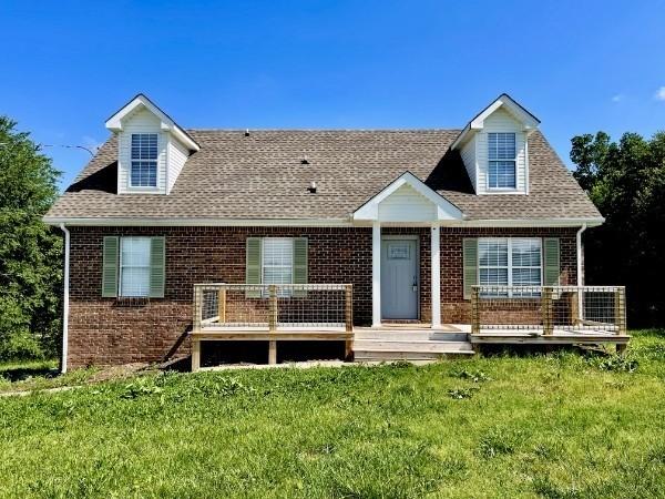 829 Tommy Oliver Rd, Clarksville, TN 37042 - view of front of home featuring brick siding, a front lawn, a shingled roof, and a wooden deck
