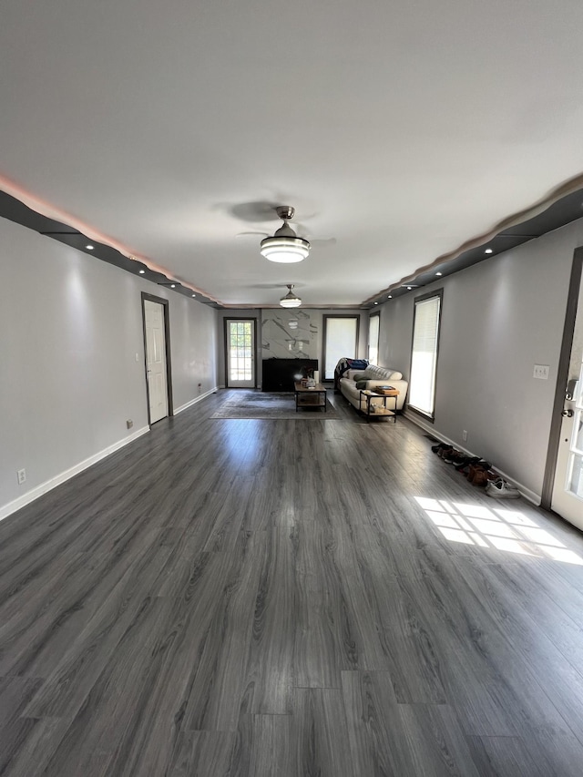 unfurnished living room featuring ceiling fan and dark hardwood / wood-style flooring