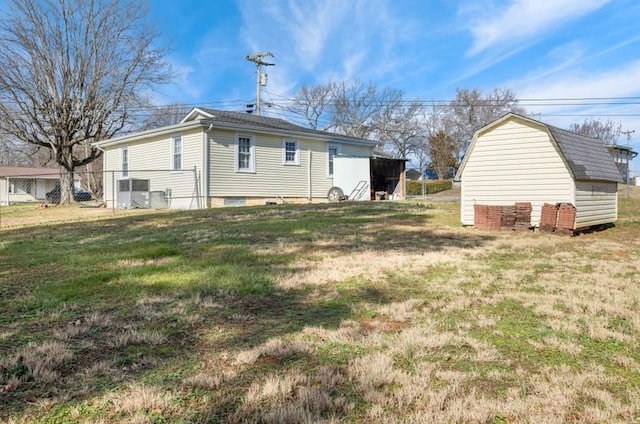 back of property featuring an outbuilding and a lawn