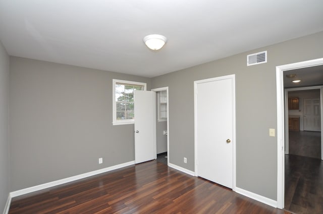 unfurnished bedroom with dark wood-type flooring
