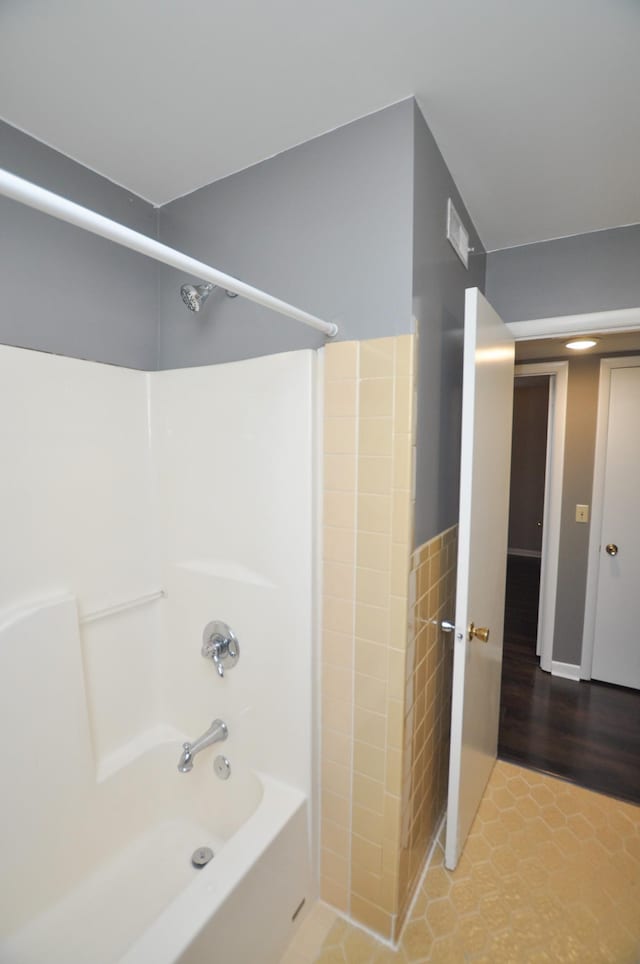 bathroom with tile patterned floors and bathtub / shower combination