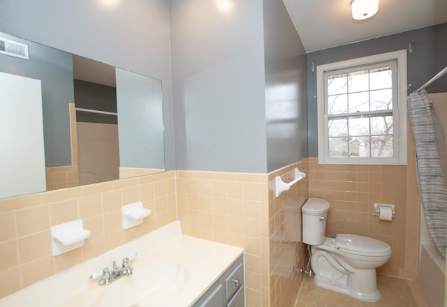 full bathroom featuring shower / bath combo, vanity, tile walls, tile patterned flooring, and toilet