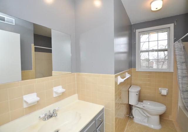 full bathroom featuring shower / bath combo, vanity, tile patterned flooring, toilet, and tile walls