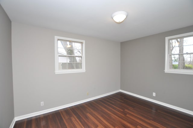 empty room with dark hardwood / wood-style flooring
