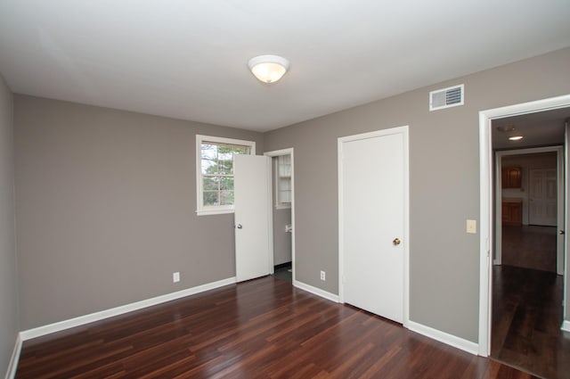 unfurnished bedroom with dark hardwood / wood-style floors