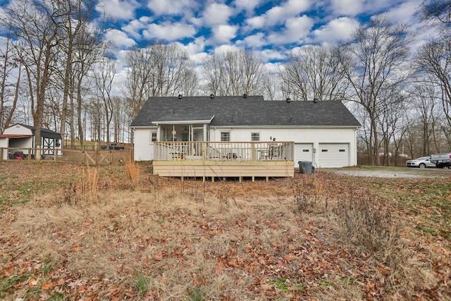 back of house featuring a deck, a garage, and a sunroom